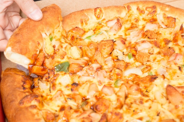 Primer plano de una pizza en la mano