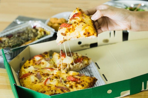 Primer plano de una pizza en la mano