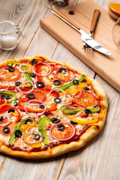 Primer plano de pizza de verduras con aceitunas y pimiento