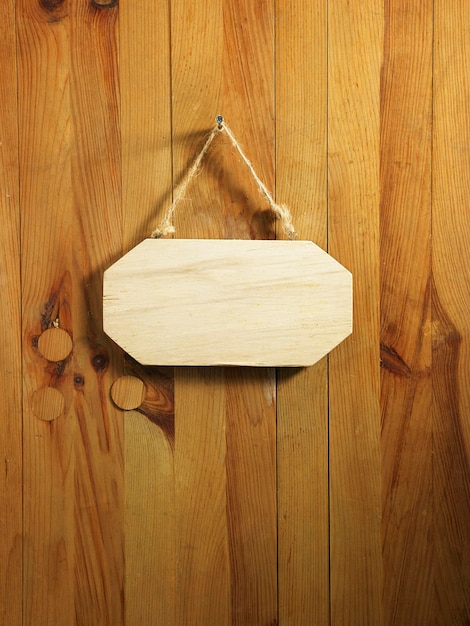 Primer plano de una placa de identificación vacía colgada en una puerta de madera