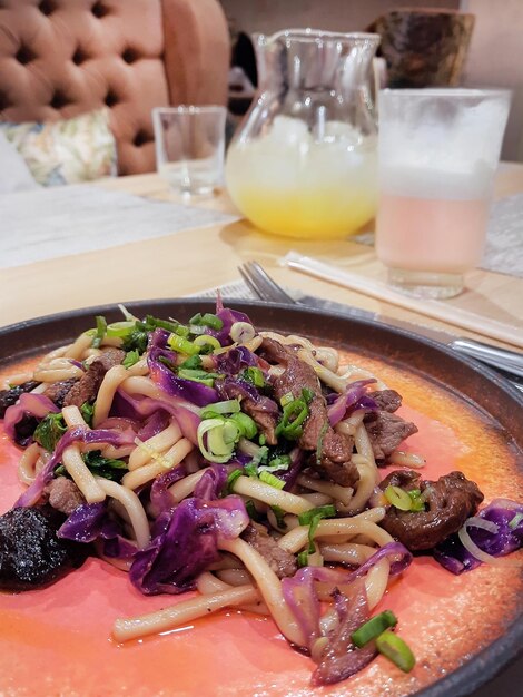 Primer plano de plato de comida asiática y bebidas en la mesa del restaurante