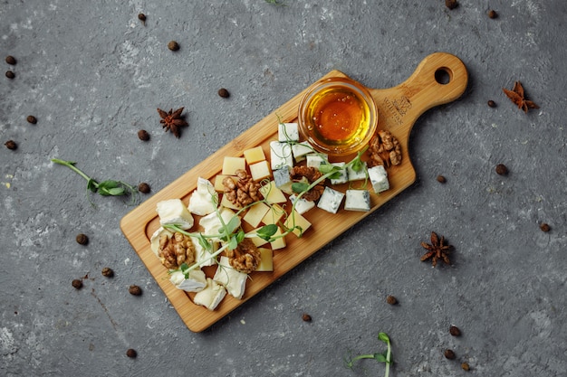 Primer plano de un plato de queso. 4 tipos de queso, queso brie blanco suave, camembert, briques semi-blandos, azul, roquefort, queso duro