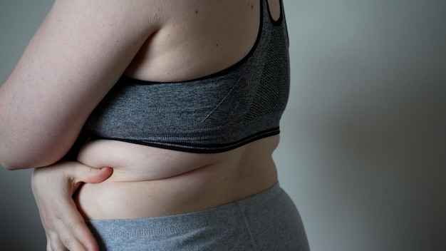 Primer plano de pliegues de grasa en el vientre grande de una mujer con sobrepeso Concepto de dieta de obesidad femenina con sobrepeso y problemas de sobrepeso