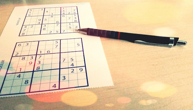 Primer plano de la pluma y el sudoku en la mesa