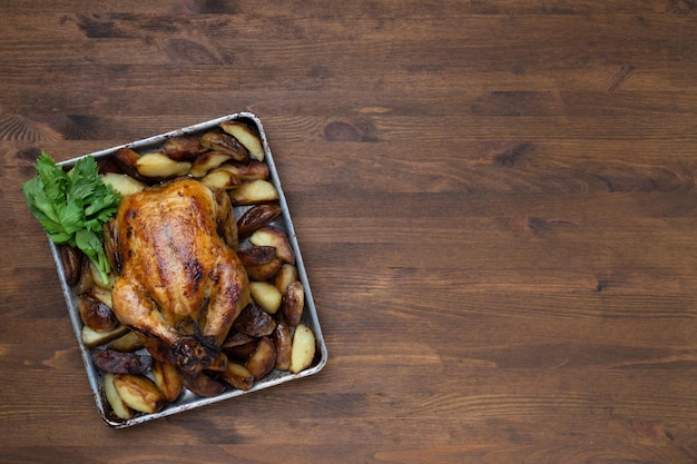 Primer plano de pollo asado en una mesa de madera, vista superior