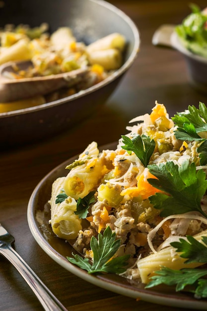 Primer plano de pollo y rigatoni servidos en un plato en la mesa