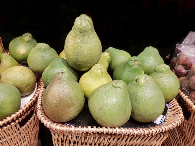 Foto primer plano de los pomelos en cesta para la venta en el puesto del mercado