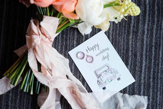 Primer plano de una postal de boda con dos anillos cerca de un hermoso ramo de novia Elementos elegantes y decoración Concepto de celebración
