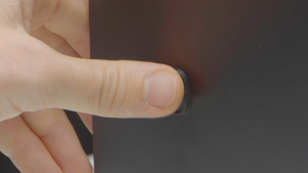Primer plano de presionar el botón de acción del botón de inicio del monitor para iniciar la computadora o dispositivo electrónico