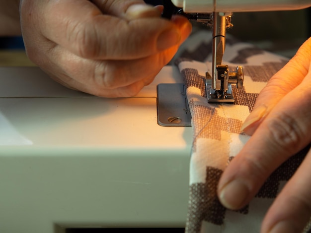 Primer plano del proceso de costura en una máquina de coser mujer cosiendo cortinas en una máquina de coser