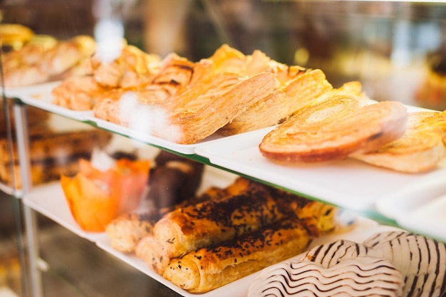 Foto primer plano de productos de pastelería dispuestos en un armario de la ventana en una panadería