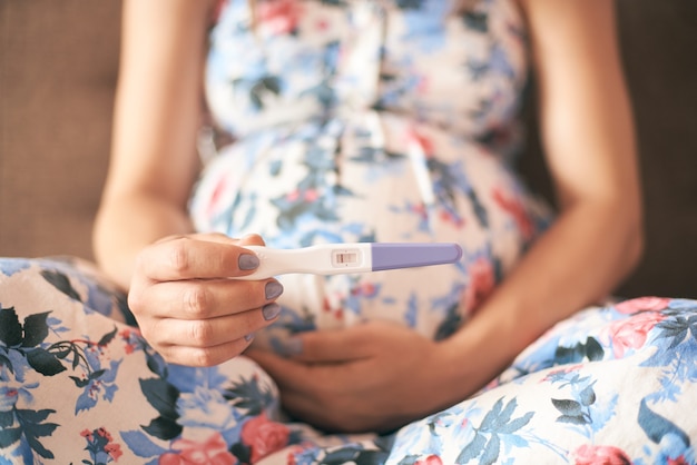 Primer plano de la prueba de embarazo en manos de una mujer joven