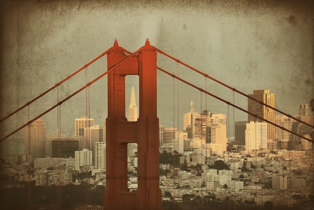 Primer plano del puente Golden Gate con el centro de San Francisco al atardecer.