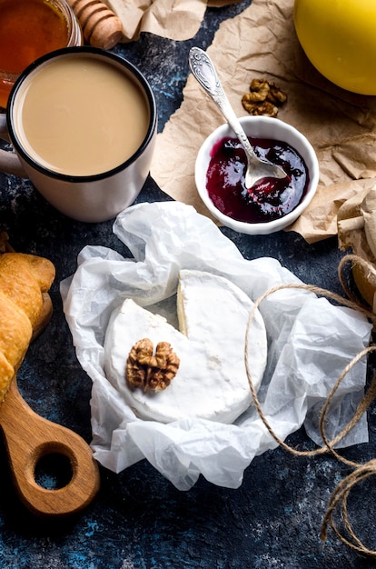 Primer plano de queso camembert con miel, nueces, vid. Plato de queso exquisito, comida de vino. Camembert, brisa. Queso francés blando. Comida italiana. Productos lácteos.