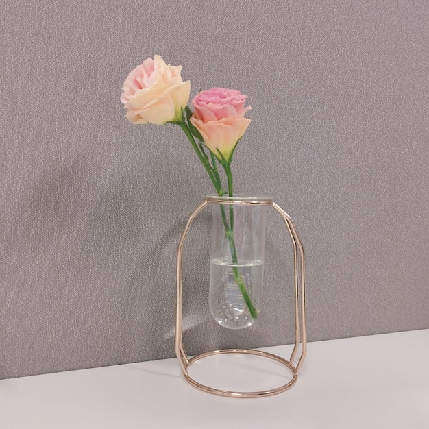 Foto primer plano de un ramo de rosas en un jarrón de vidrio en la mesa