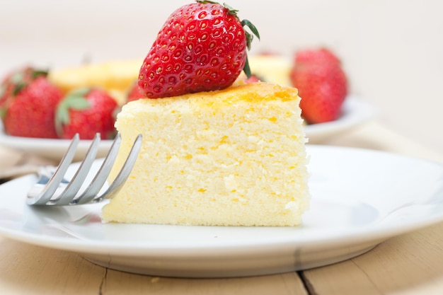 Primer plano de una rebanada de pastel de queso con fresas en el plato