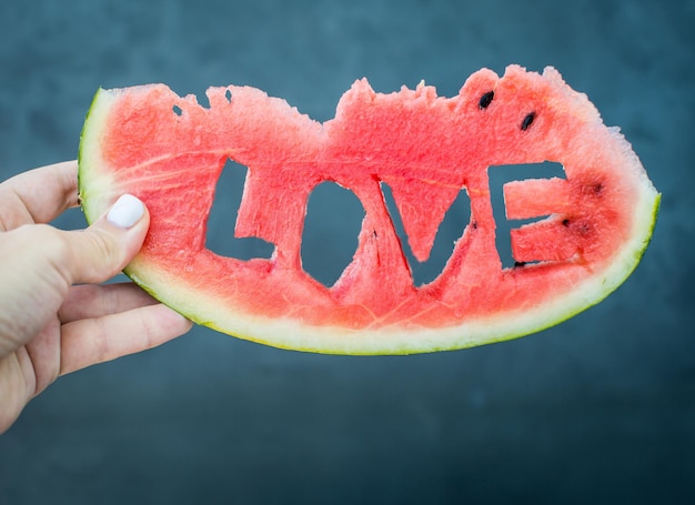 Primer plano de rebanada de sandía jugosa fresca con palabra de letras de amor