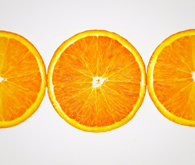 Foto primer plano de las rebanadas de naranja contra un fondo blanco
