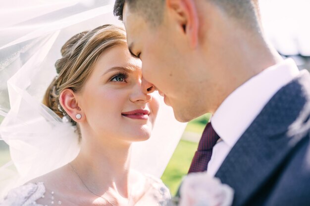 Primer plano de los recién casados la mirada enamorada de la novia mira al novio el día de la boda