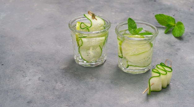 Primer plano de refrescante agua de desintoxicación infundida con menta lima y pepino sobre fondo gris con espacio de copia Cóctel de verano Cuidado de la salud fitness concepto de comida saludable