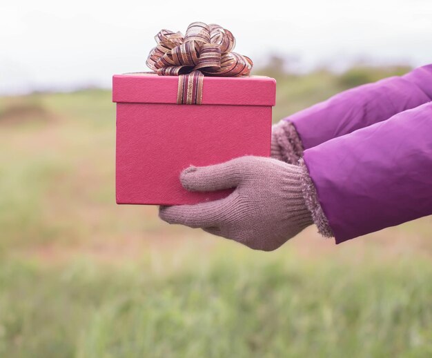 Foto primer plano del regalo en la mano en el campo