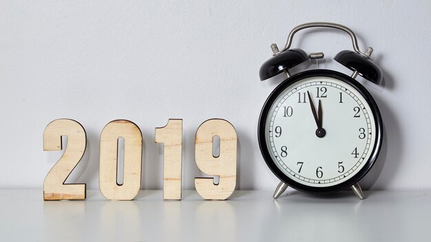 Primer plano del reloj y 2019 en la mesa contra la pared