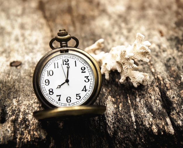 Foto primer plano de un reloj de bolsillo antiguo en una mesa de madera