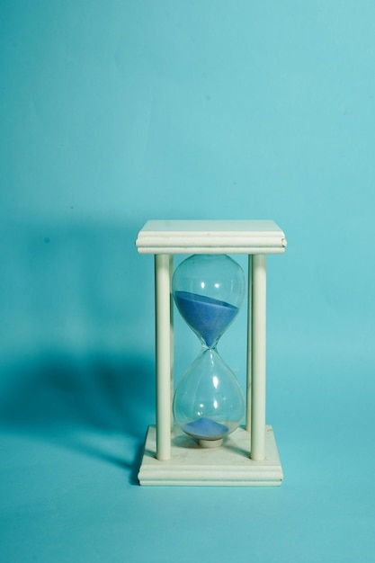 Primer plano del reloj en la mesa contra la pared azul