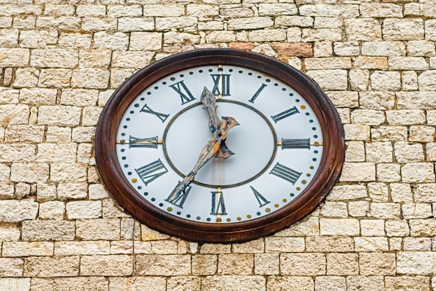Primer plano del reloj en la pared de piedra