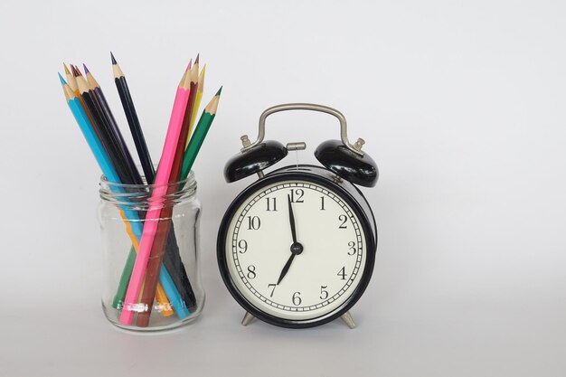 Primer plano del reloj sobre la mesa contra el fondo blanco.
