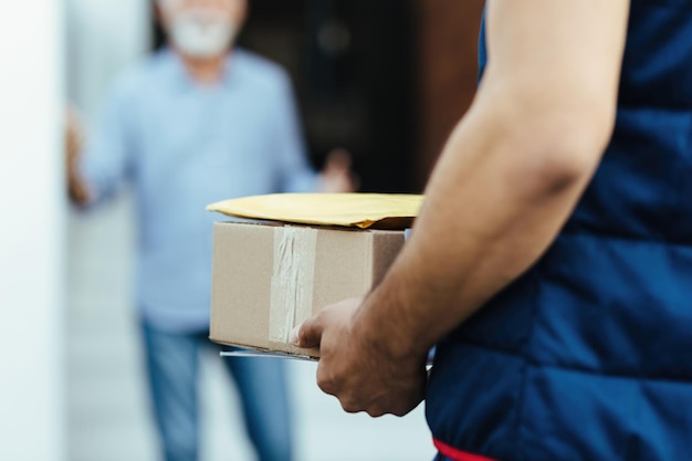 Foto primer plano del repartidor que lleva paquetes a su cliente.