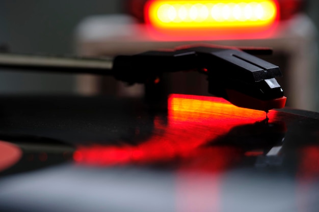 Primer plano de un reproductor de discos de vinilo clásico con luz roja contorneada