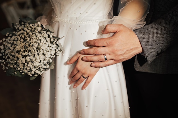 Primer plano retrato de los encantadores recién casados con anillos en los dedos