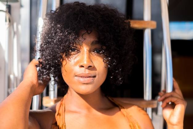 Primer plano y retrato de hermosa mujer afro mirando a la cámara - feliz dama americana o africana sonriendo