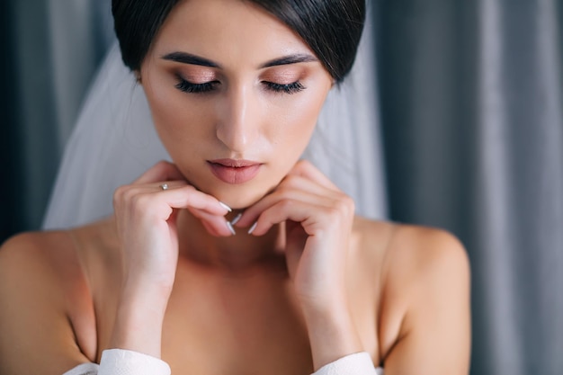 Primer plano retrato de hermosa novia morena antes de la boda con maquillaje perfecto