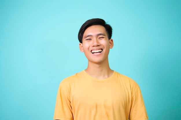 Primer plano retrato de joven guapo sonriente en camiseta amarilla fondo aislado