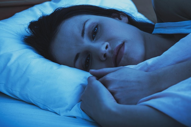 Primer plano del retrato de una mujer durmiendo en la cama