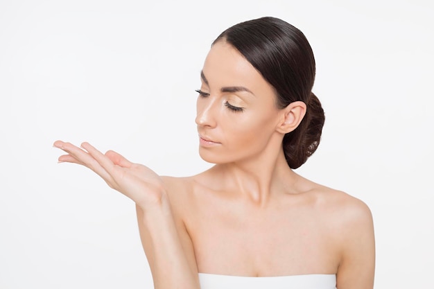 Primer plano retrato de mujer joven con cara de belleza y piel facial saludable Hermosa modelo de niña sonriente con maquillaje natural tocando piel hidratada brillante Cosmetología belleza y Spa Cuidado de la piel