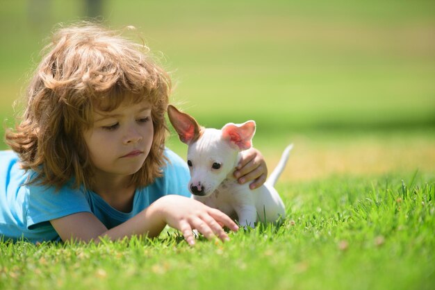 Primer plano retrato de niño abrazando perro Emociones positivas de los niños Niños divertidos jugando con su cachorro en el parque Chihuahua mezclado Los niños abrazan amorosamente a su perro mascota