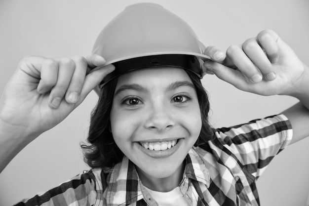 Primer plano retrato de niño constructor en casco Adolescente en trabajos de reparación aislado sobre fondo amarillo Concepto de renovación de niños