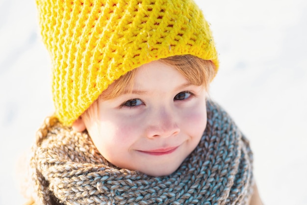 Primer plano retrato de niño hermoso sobre fondo nevado frío y viajes turismo de invierno holi activo