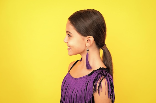 Primer plano retrato de perfil de una jovencita caucásica Disparo a la cabeza de un niño adolescente lindo sobre fondo de estudio aislado amarillo