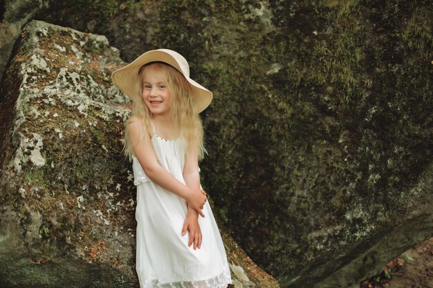 Primer plano retrato ucraniano niña de 7 años asiento en piedra en el bosque