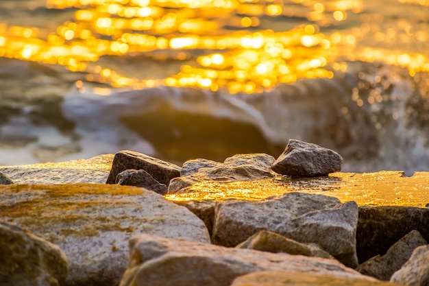 Foto primer plano de una roca en la orilla del mar durante la puesta de sol