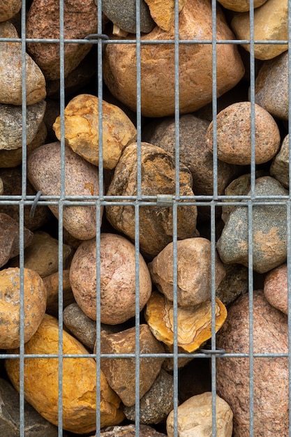 Primer plano de rocas detrás de una malla metálica delgada