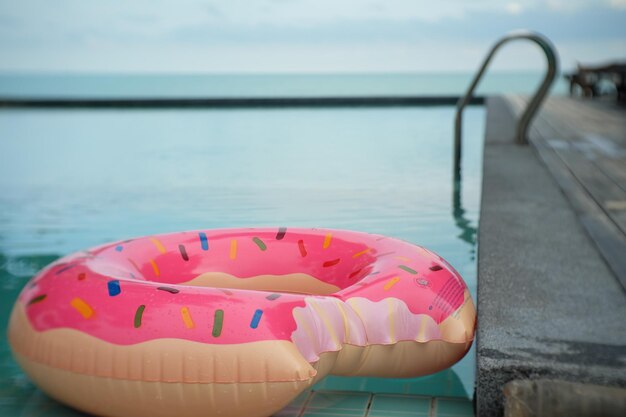 Foto primer plano de rosa flotando en una piscina contra el mar