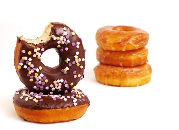 Primer plano de rosquillas con glaseado de chocolate y salpicaduras contra un fondo blanco