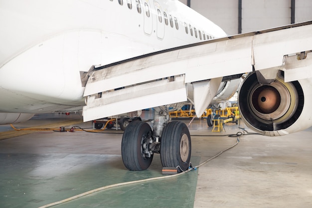 Primer plano de la rueda del avión, tren de aterrizaje en el hangar del aeropuerto. Avión, envío, concepto de transporte