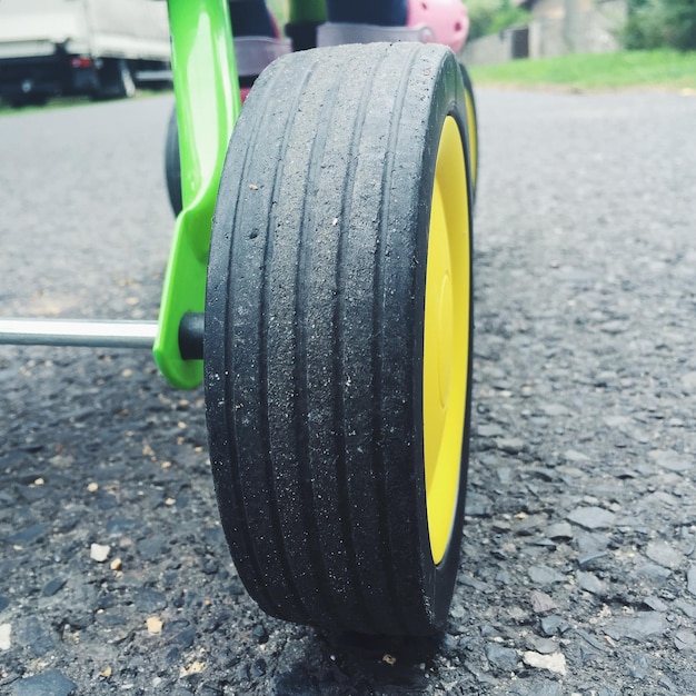 Foto primer plano de la rueda del triciclo en la carretera