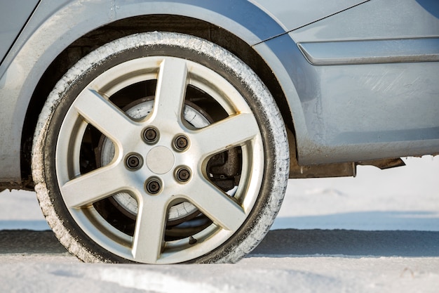 Primer plano de las ruedas del coche neumático de goma en nieve profunda